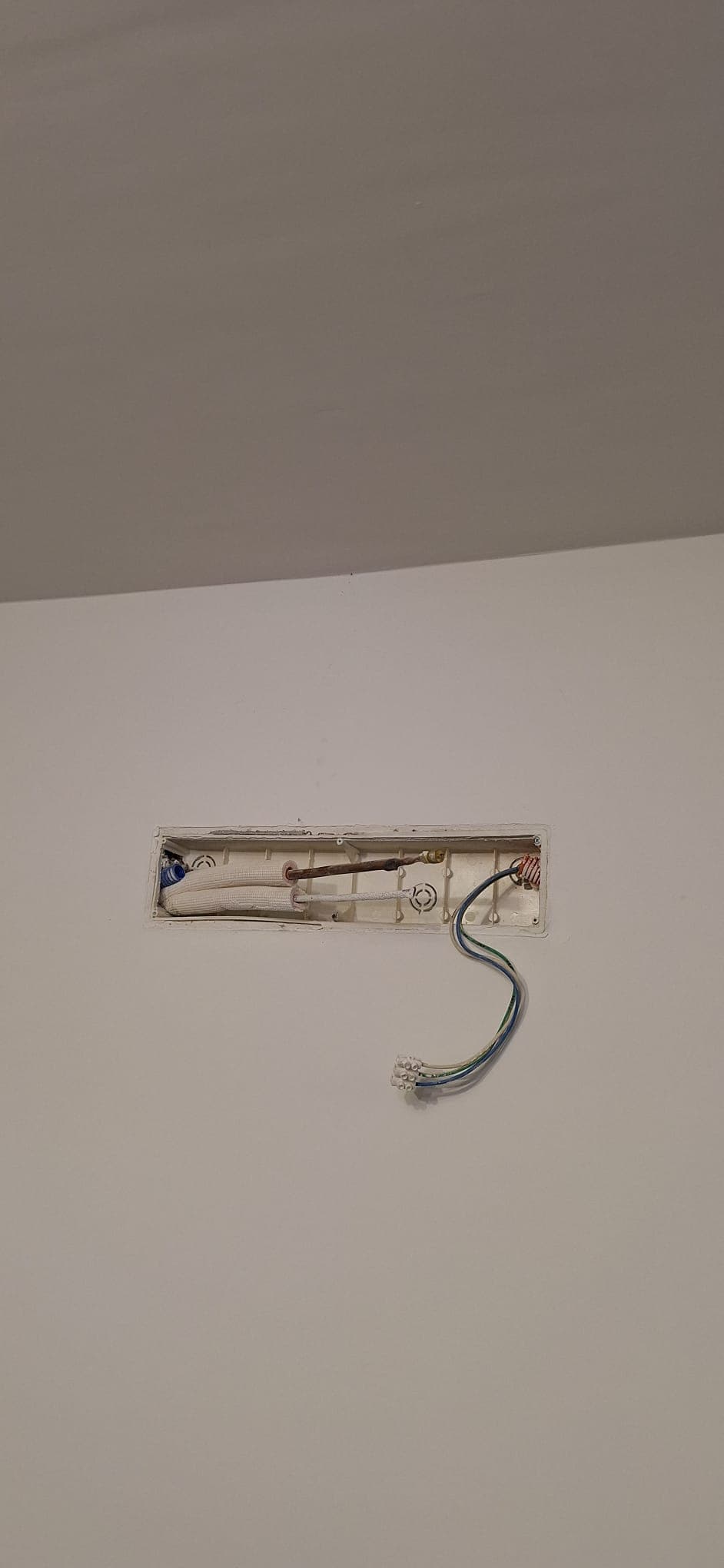 Paso de cañerías y cableado terminado y tapado con su registro, listo para conectar la unidad interior.